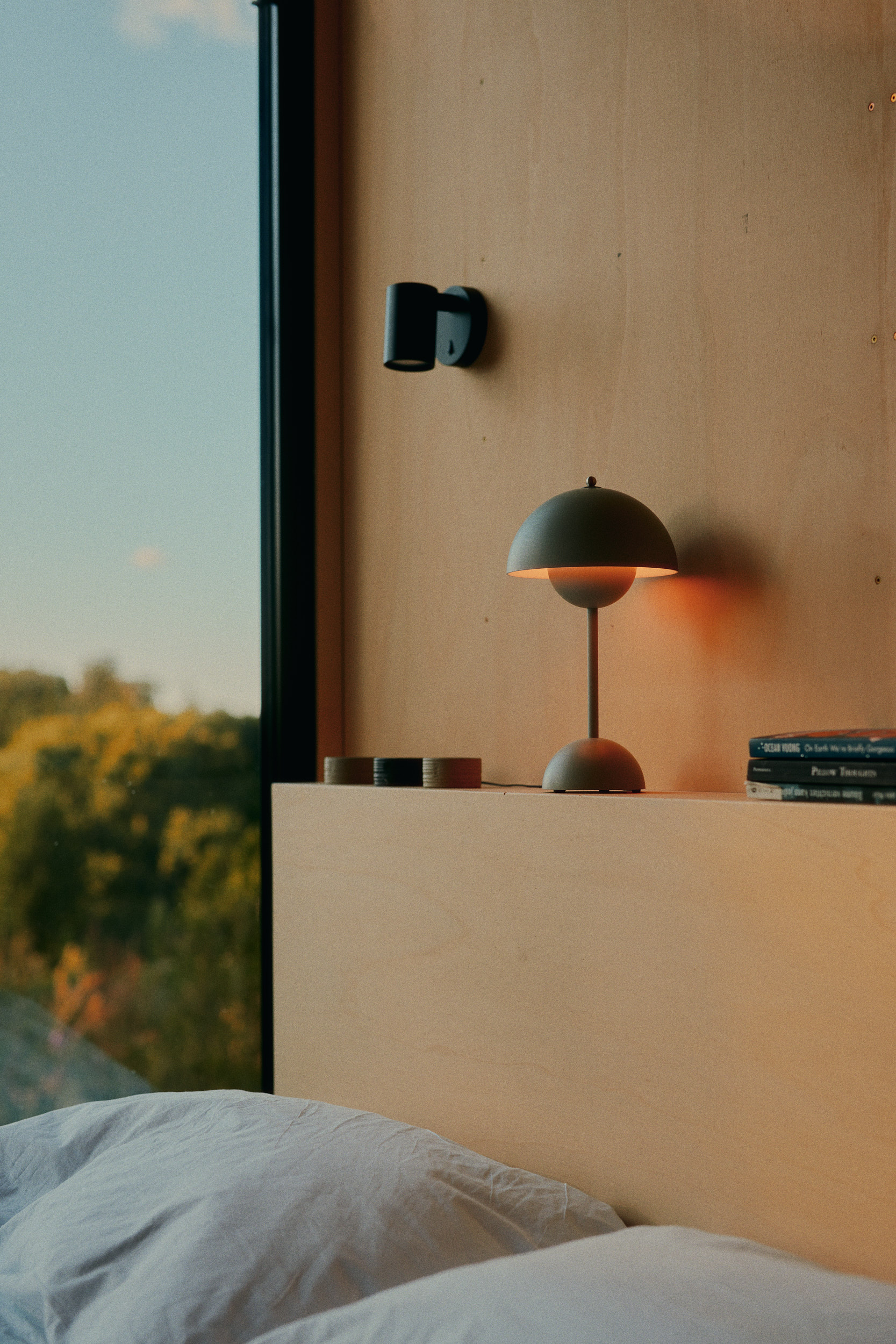 Detailaufnahme: Holzoberflächen, Textilien und behagliche Einrichtung in einer Raus Cabin – Interior Fotografie mit Fokus auf Licht und Material
