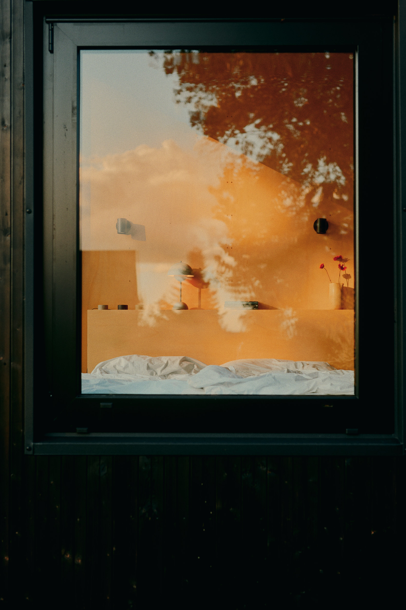 piel von Licht und Schatten durch Fenster einer Cabin, Innenraum mit warmem Holz im Kontrast zum kühlen Außenlicht – Interior Fine Art Fotografie.
