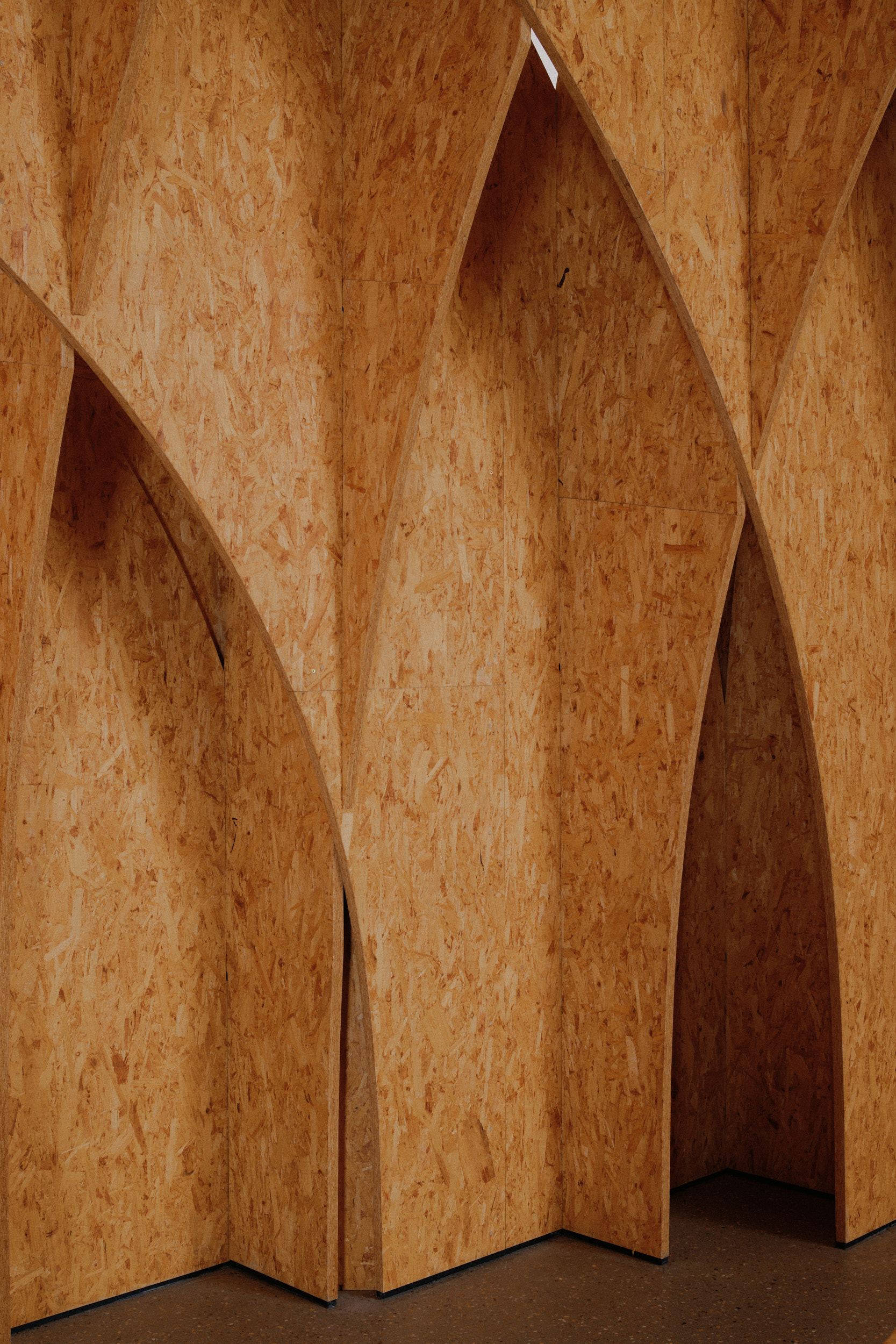Interior photography of Autobahnkirche Siegerland showing the warm timber interior, wooden vaulted structure and quiet sacred atmosphere, captured by Hamburg architectural photographer David Altrath.