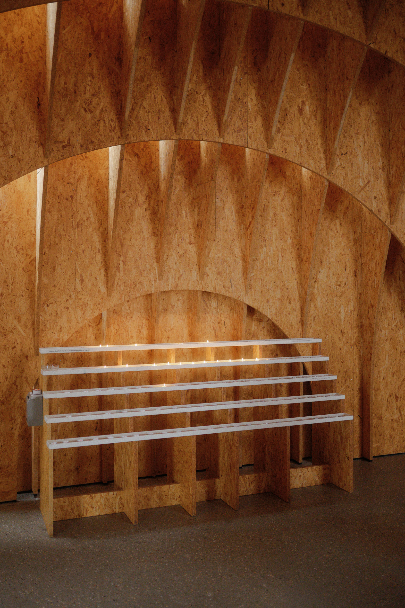 Interior view of Autobahnkirche Siegerland with timber walls, altar and soft daylight from above.