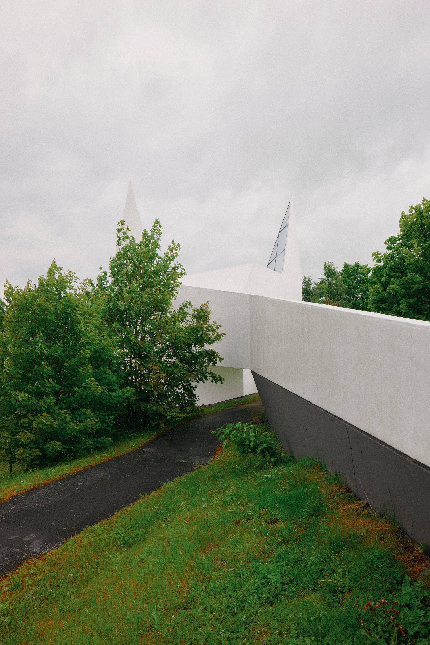 White exterior of Autobahnkirche Siegerland beside the A45, captured in precise architecture photography by David Altrath.
